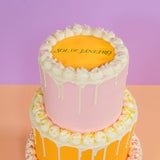 3 Tier Corporate Drip Cake with logo by Crumbs & Doilies, featuring pastel drip icing and custom edible logo plaque.